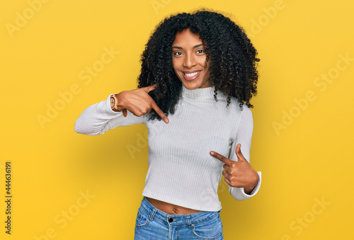 Young african american girl wearing casual clothes looking confident with smile on face, pointing oneself with fingers proud and happy.