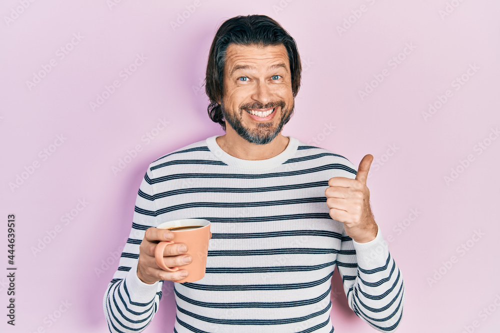 Middle age caucasian man drinking a cup of coffee smiling happy and positive, thumb up doing excellent and approval sign Middle age caucasian man drinking a cup of coffee smiling happy and positive, thumb up doing excellent and approval sign