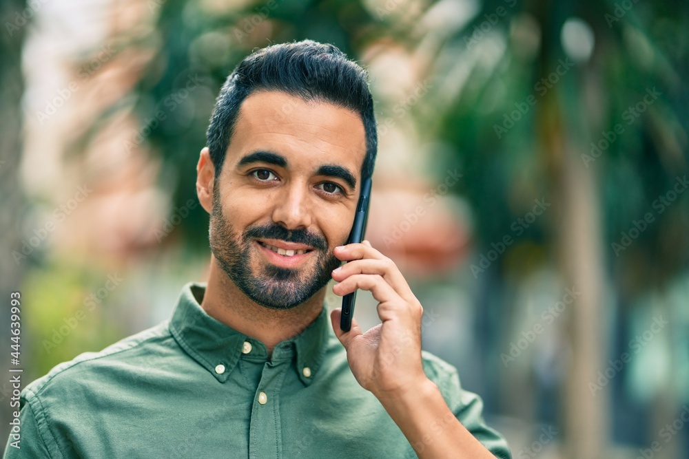 Young hispanic man smiling happy talking on the smartphone at the city. Young hispanic man smiling happy talking on the smartphone at the city.