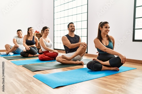 Group of young people smiling happy training yoga at sport center.