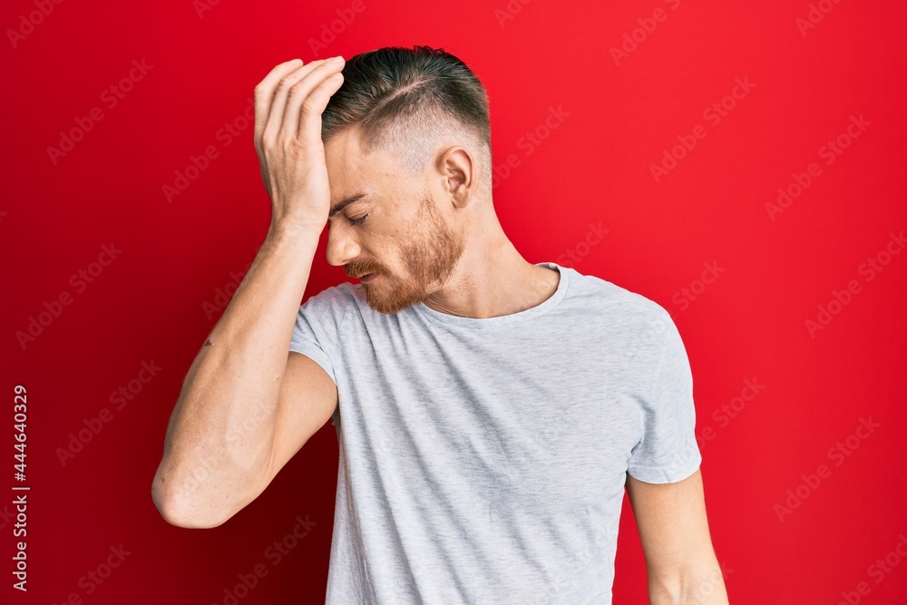 Young redhead man wearing casual grey t shirt surprised with hand on head for mistake, remember error. forgot, bad memory concept. Young redhead man wearing casual grey t shirt surprised with hand on head for mistake, remember error. forgot, bad memory concept.