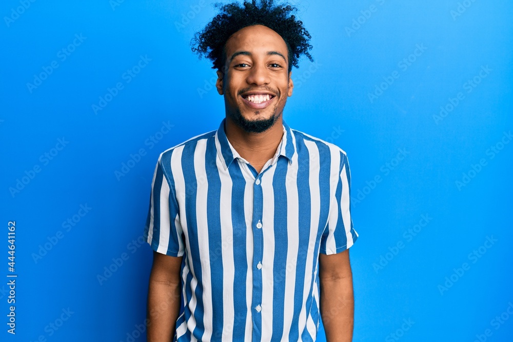 Young african american man with beard wearing casual striped shirt with a happy and cool smile on face. lucky person. Young african american man with beard wearing casual striped shirt with a happy and cool smile on face. lucky person.