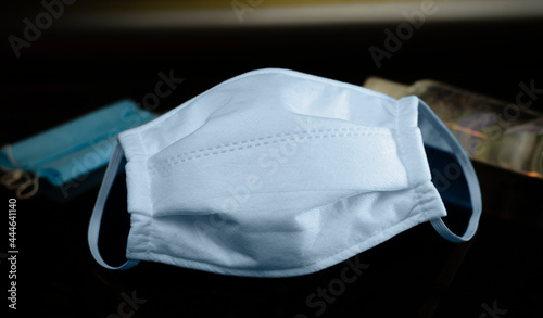 Cubrebocas azul oscuro higiénico de algodón en fondo negro - Mascarilla para protegerse del covid 19 con alcohol desinfectante de fondo