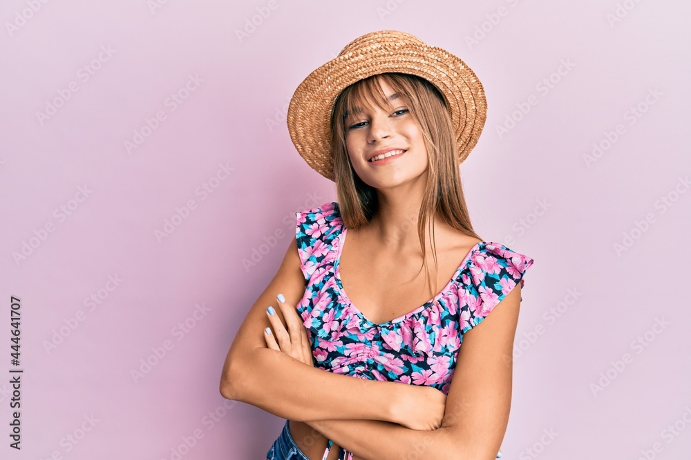 Teenager caucasian girl wearing summer hat happy face smiling with crossed arms looking at the camera. positive person.