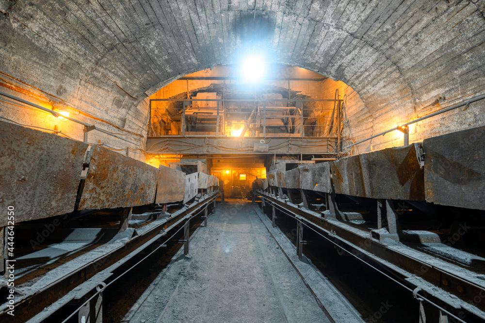 Obraz premium Belt conveyor system in an underground tunnel. Transportation of ore to the surface