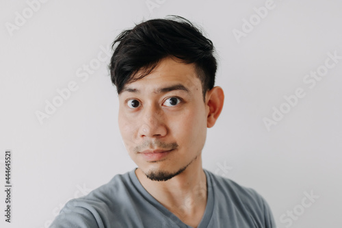 Selfie photo of Asian man in blue t-shirt isolated on white background.