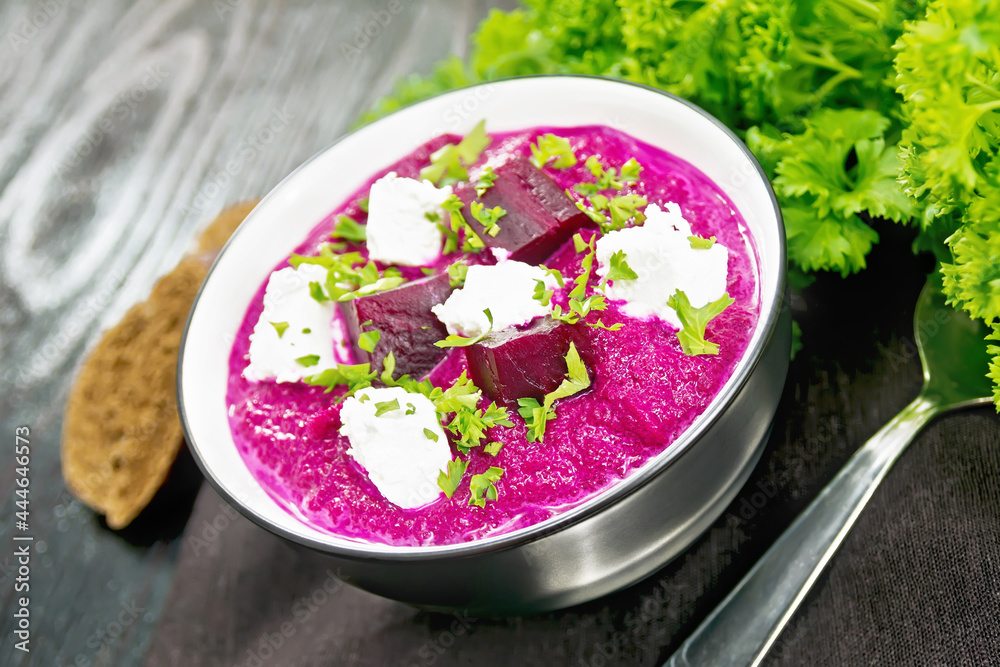 Soup puree of beetroot with salted cheese in bowl on black board Soup puree of beetroot with salted cheese in bowl on black board