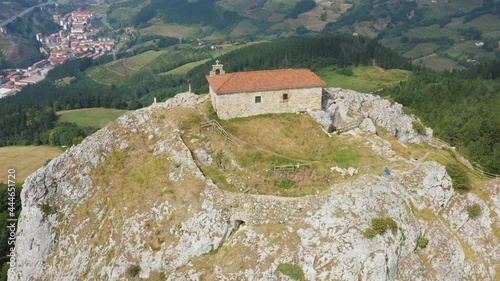 Aerial drone view of the hermitage of Aitzorrotz on top of a mountain in the Basque Country photo