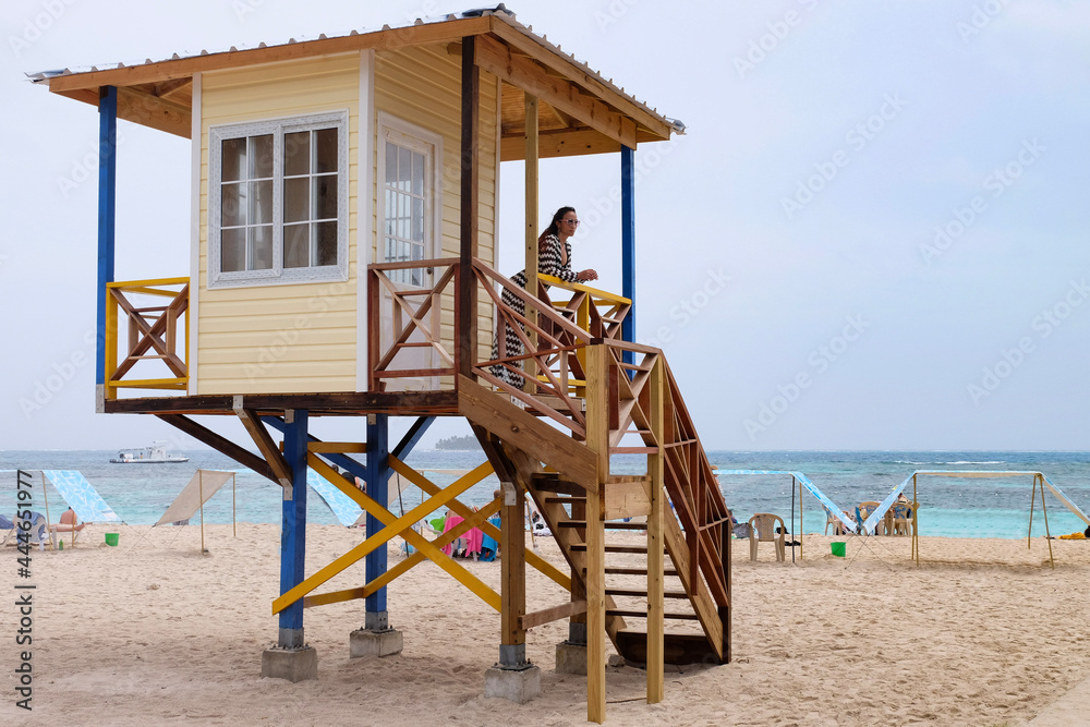 woman watching from a lifeguard hut on the beach