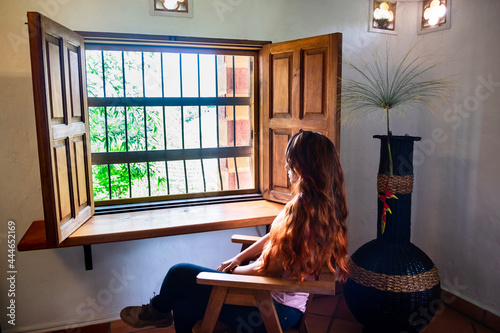 Obraz na płótnie ed haired woman looking through a wooden window w salonie