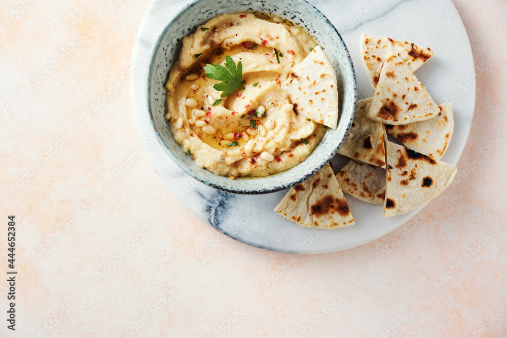 Homemade hummus with pine nuts and pita slices. Homemade hummus with pine nuts and pita slices.