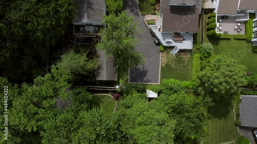 Overhead suburban neighborhood with push up over rooftops, trees, backyards, sidewalks, driveways and street. photo
