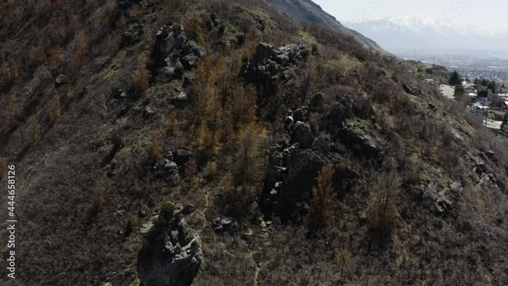 Reverse aerial drone shot of Rock Canyon mountainside with town in background. Reverse aerial drone shot of Rock Canyon mountainside with town in background.