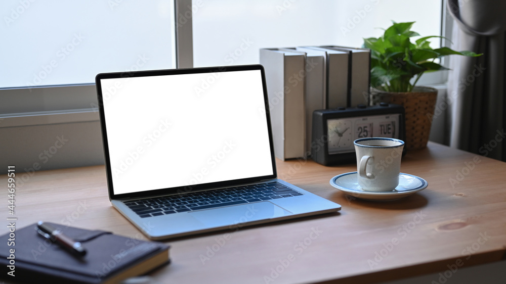 Fototapeta premium Home office desk with laptop computer, notebook, coffee cup and houseplant.
