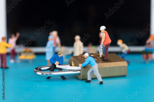 Models of mobile phones and miniature figures and workers trying to saw and crack the code lock