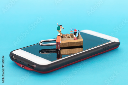 фотографія Miniature photography doll tries to open the code lock on the phone