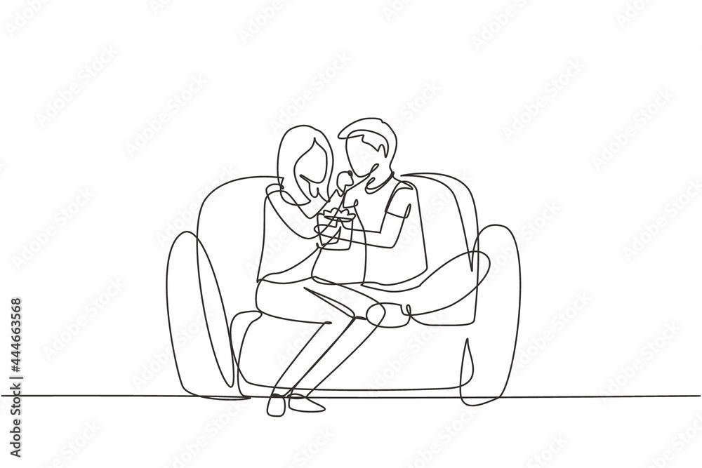 Single continuous line drawing romantic couple sitting relaxed together on sofa, woman feeding popcorn to man. Celebrate wedding anniversary. Dynamic one line draw graphic design vector illustration Single continuous line drawing romantic couple sitting relaxed together on sofa, woman feeding popcorn to man. Celebrate wedding anniversary. Dynamic one line draw graphic design vector illustration