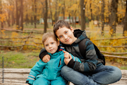 Obraz na płótnie Little brother with brother sit at the outdoor