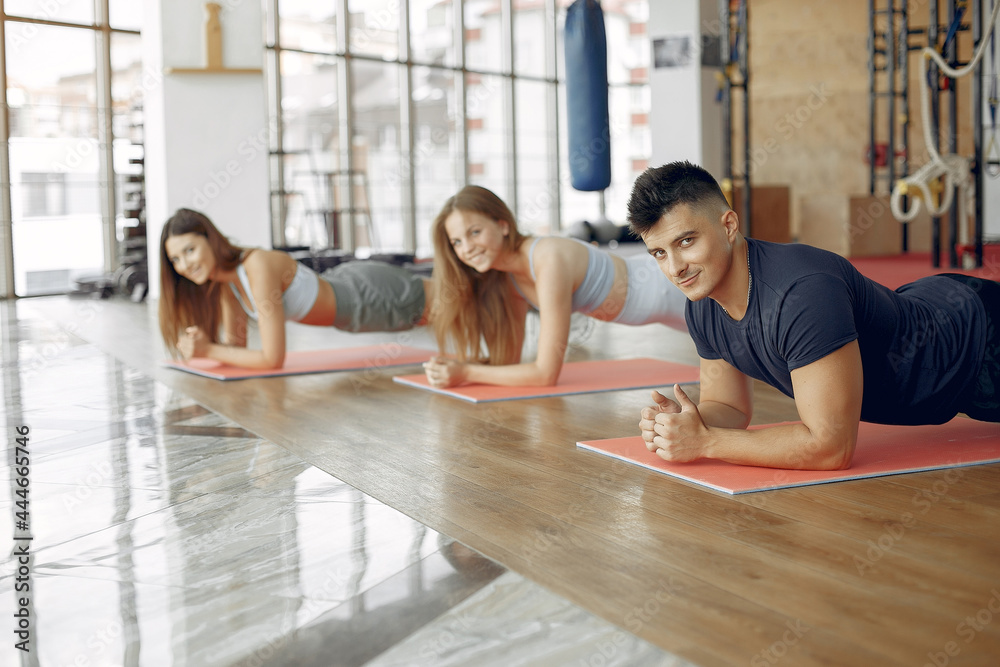 Obraz premium Young sports people training in a morning gym