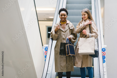 Happy mixed girls walking the store with shopping bags