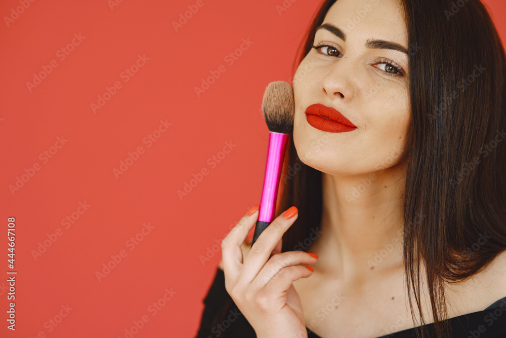 Woman in a black dress standing on a red background