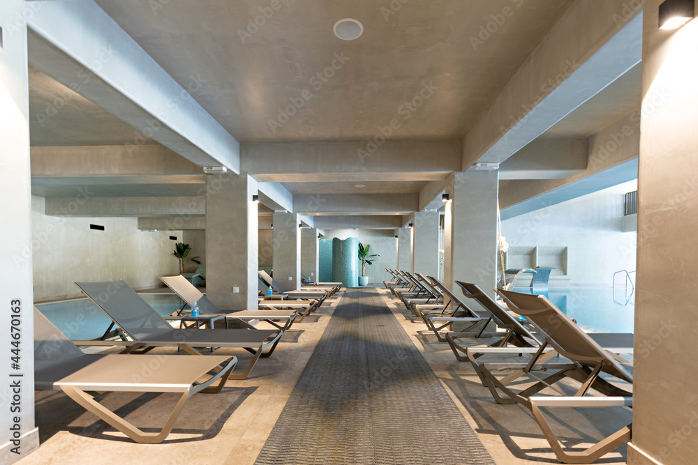Sunbeds in a row in indoor swimming pool