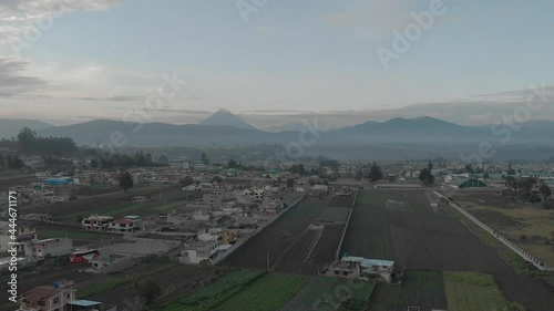 Town and volcano during sunrise in Andes of Ecuacor. Volcano Tungurahuaand Andean Peaks. High Altitude Drone Shot Of Ambato, Ecuador