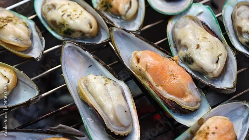 Grilled Green Shell mussels with butter and garlic, Grilled New Zealand mussels or Perna Canaliculus on a hot charcoal stove.
