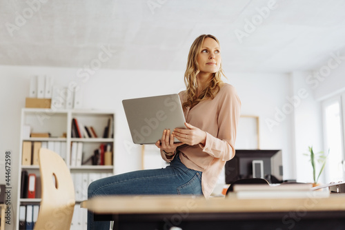 Low angle view of a businesswoman perched on a table