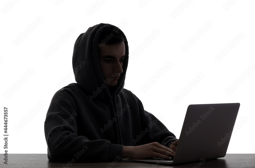 Silhouette of hacker with laptop at table on white background Silhouette of hacker with laptop at table on white background