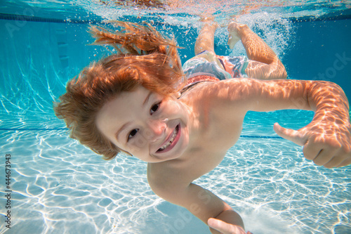 Canvas Print Happy kid boy swim and dive underwater, kid with fun in pool under water