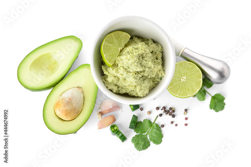 Mortar with tasty guacamole, avocado, lime and garlic on white background