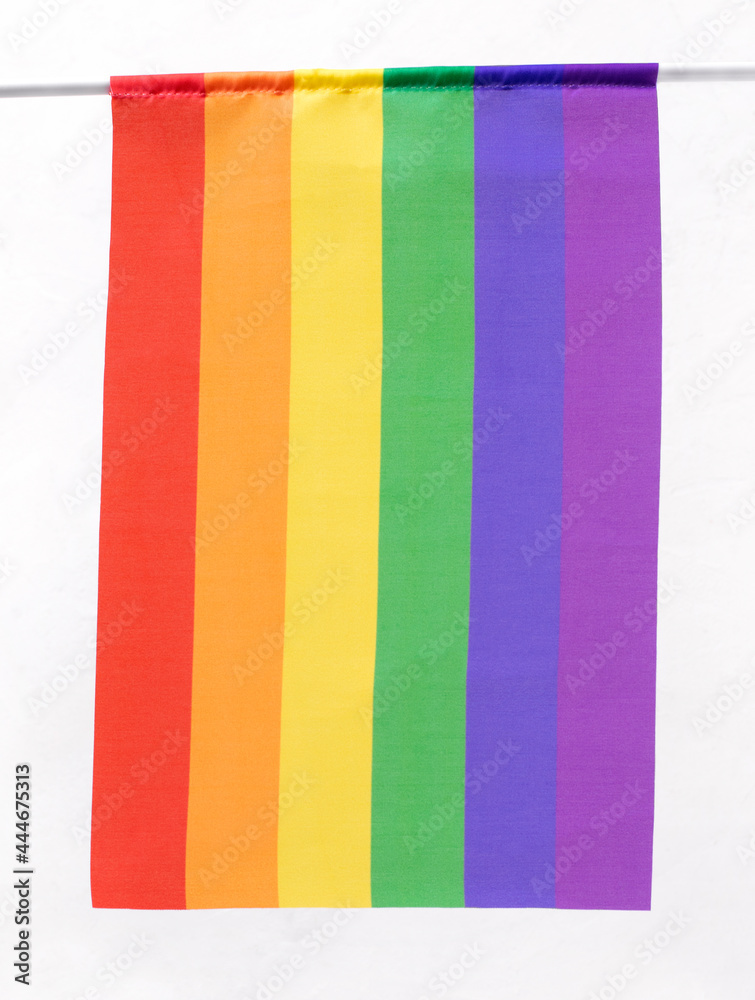 LGBT flag in rainbow colors on flagpole against the white background. LGBTQ community pride symbol