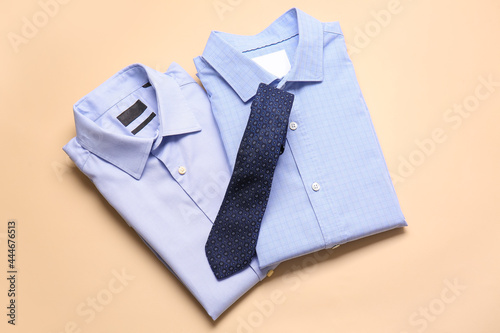 Stylish male shirts with tie on color background