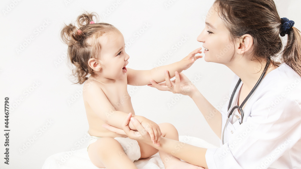 Pediatrician is taking care of baby in hospital. Little girl is being examined by doctor with stethoscope. Health care, medicine and help concept. Pediatrician is taking care of baby in hospital. Little girl is being examined by doctor with stethoscope. Health care, medicine and help concept.