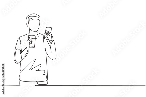 Single one line drawing smiling handsome man looking at mobile phone and holding glass of orange juice while having breakfast at home. Modern continuous line draw design graphic vector illustration
