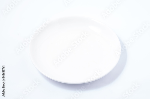 White ceramic plate on a white table. For food, advertising space.