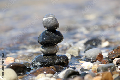 Tower of pebbles on blurred background of the sea waves. Summer vacation, balance and relax concept