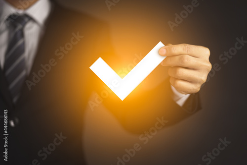 Businessman hand holding virtual approved check mark and Checklist concept photo