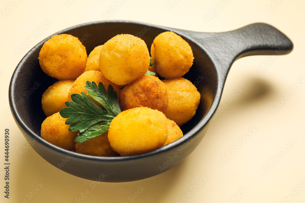 Dish with fried potato balls on color background Dish with fried potato balls on color background