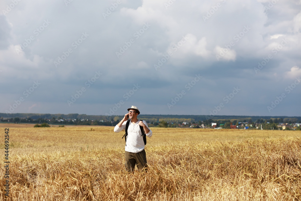 Tourist in a field of cereal plants. A man in a wheat field. Grain harvest. Tourist in a field of cereal plants. A man in a wheat field. Grain harvest.