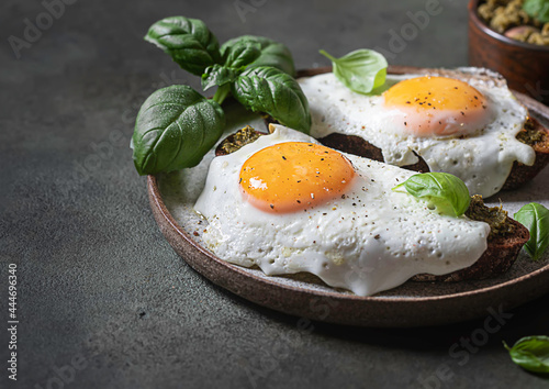 Croque-madame with fried egg , pesto sauce and basil. Traditional French Toasted Sandwich. French cuisine.