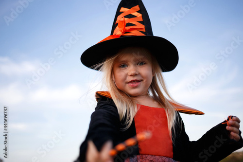 little cute girl dressed as a witch celebrates halloween