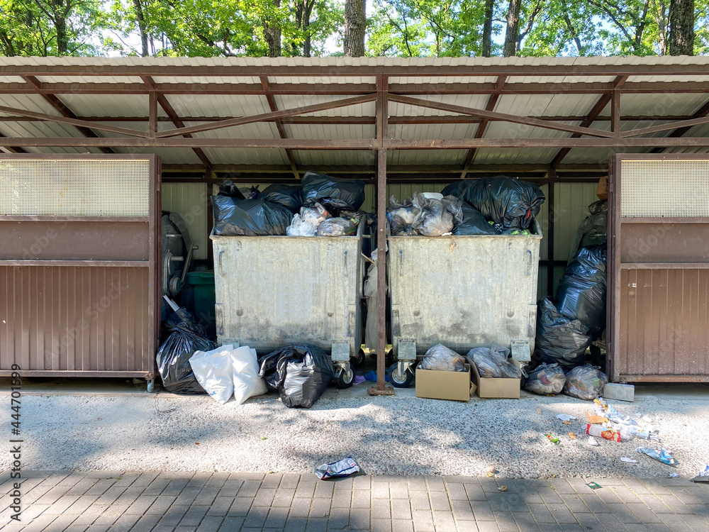 Bags of garbage are in the trash container. A lot of garbage was thrown into containers