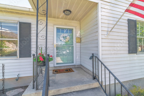 Facade of home on real estate listing with storm door and glass pened front door