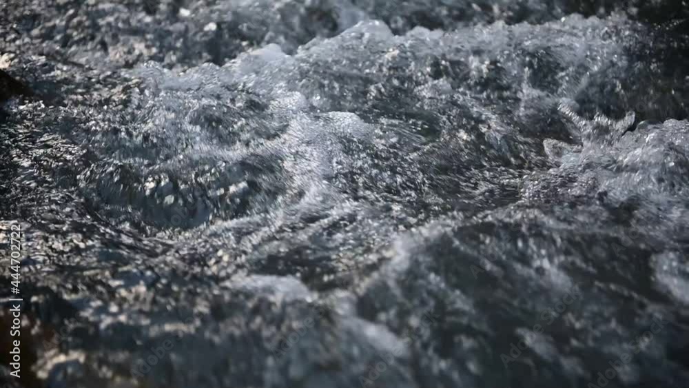 Slow motion of wild clear mountain river , stream flowing through rocks. Close up of river stones with flowing water, clean water flowing in a mountain river Slow motion of wild clear mountain river , stream flowing through rocks. Close up of river stones with flowing water, clean water flowing in a mountain river