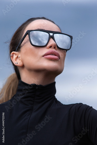 Young girl in sunglasses and a black blouse. Close-up portrait.