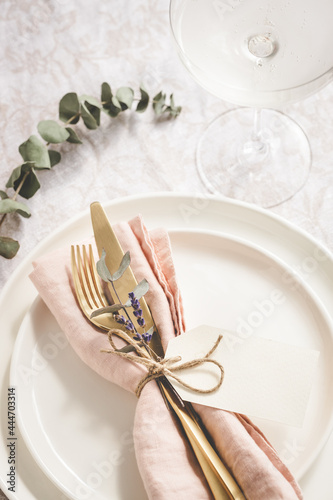 Table setting details with lavender and eucaliptus on white plates.