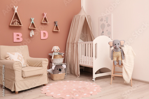 Baby room interior with stylish furniture and comfortable crib photo