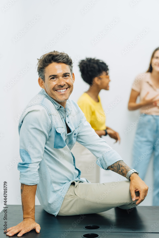 Portrait of office worker smiling to camera in big and creative office. Portrait of office worker smiling to camera in big and creative office.
